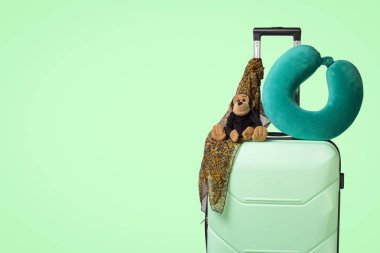 Tekerlekli, yumuşak oyuncak, plastik bavul seyahat yastık, boyun atkı, yeşil renkli. Bir yaz tatili, akraba ziyareti, kamp gezisi seyahat kavramı