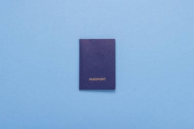 Arka plan mavi pasaportla. Minimalizm tarzı. Seyahat ve tatil kavramı. Düz yatıyordu, en iyi görünümü