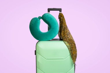 Plastik seyahat çantası ve SAP, pembe bir arka plan üzerinde seyahat yastık üzerinde ekli bir eşarp. Seyahat, iş gezileri, ziyaret arkadaş ve akrabaları kavramı