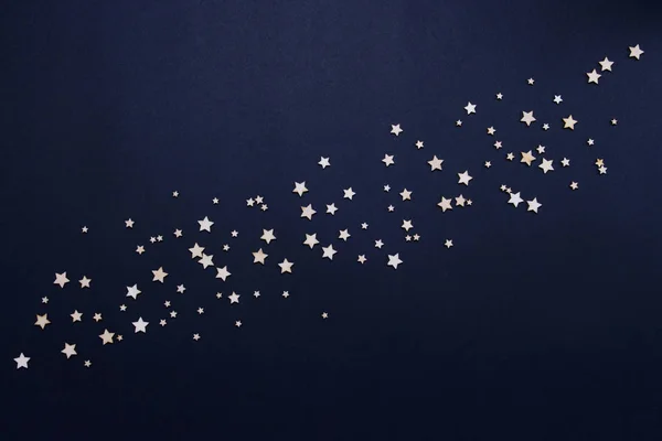 Διακοσμητικά αστέρια σε σκούρο μπλε φόντο. Έννοια του νυχτερινού ουρανού. Μπορεί να χρησιμοποιηθεί ως ταπετσαρία ή φόντο. Επίπεδη lay, κορυφαία προβολή — Φωτογραφία Αρχείου