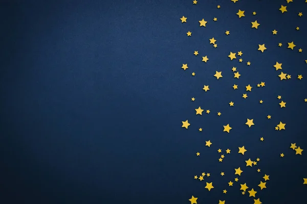 Estrellas decorativas sobre fondo azul oscuro. Concepto del cielo nocturno. Se puede utilizar como fondo de pantalla o fondo. Piso tendido, vista superior — Foto de Stock