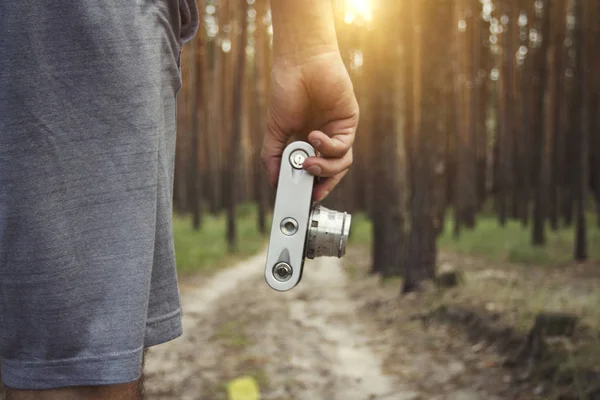 남자 그의 손에 숲길의 배경에 카메라를 보유 하고있다. 숲, 산에에서 하이킹 하는 동안 자연에 사진을 찍고 촬영의 개념 — 스톡 사진
