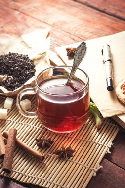 Bir fincan çay, baharat, tatlılar, ahşap bir masa üzerinde kalem ile zarf