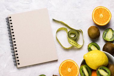 Defter girişleri, ölçüm bandı ve organik meyve için hafif bir taş zemin üzerine