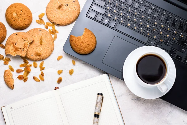 Homemade Oatmeal Cookies, Coffee Cup, Diary and Laptop on a Light Stone Background