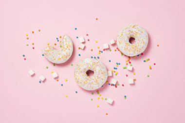 Taze lezzetli tatlı çörek, çok renkli dekoratif şekerleme, pembe bir arka plan üzerinde kesme şeker. Fırın kavramı, taze hamur işleri, lezzetli breakfast, lokanta. Düz yatıyordu, en iyi görünümü.