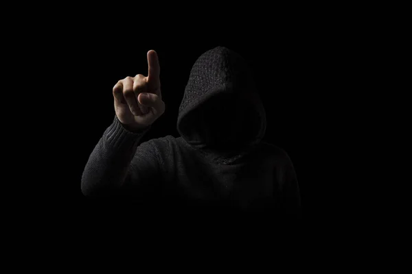 Hombre sin rostro en una capucha con un dedo aparece sobre un fondo oscuro — Foto de Stock
