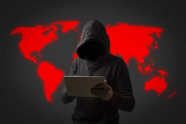 Anonieme man in een hoodie met capuchon houdt een tablet in zijn handen op een donkere achtergrond. Concept van het hacken van gebruikersgegevens. Gehackt lock, creditcard, cloud, e-mail, wachtwoorden, persoonlijke bestanden — Stockfoto