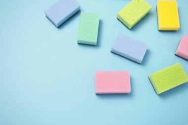 Temizleme Aksesuarları, sünger vardır rasgele mavi bir arka plan üzerinde dağınık. temizlik hizmet anlayışı. Düz yatıyordu, en iyi görünümü