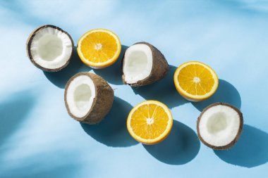 Turuncu ve hindistan cevizi gölgeler ile doğal ışık altında mavi bir arka plan üzerinde. Sert ışık. Diyet kavramı, sağlıklı beslenme, tropik tatil, tatil ve seyahat.