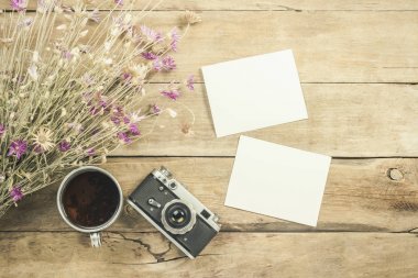 Yabani çiçekler, bir fincan çay, bir pusula ve tahta arka planda yürüyüş için diğer özellikler. Dağlarda ya da ormanda yürüyüş, turizm, çadır istirahatı, kamp kavramı. Düz yatış, üst görünüm.