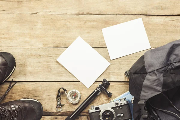 Laarzen, rugzak, kompas en andere kampeerspullen op een houten achtergrond. Het concept van wandelen in de bergen of het bos, toerisme, tent rust, kamp. Platte lay, bovenaanzicht. — Stockfoto