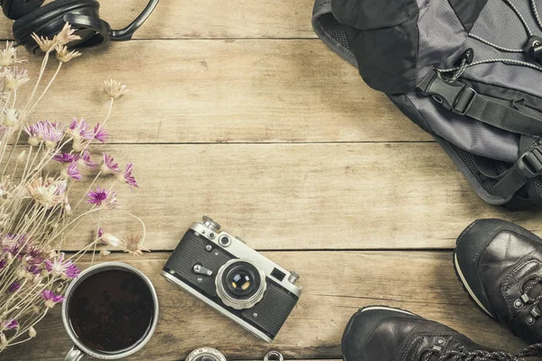 Boots, backpack, compass and other camping gear on a wooden background. The concept of hiking in the mountains or the forest, tourism, tent rest, camp. Flat lay, top view.