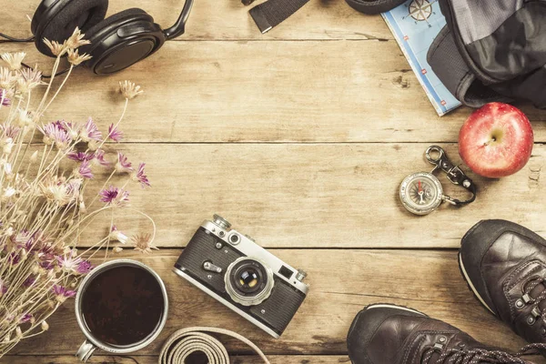 Boots, backpack, compass and other camping gear on a wooden background. The concept of hiking in the mountains or the forest, tourism, tent rest, camp. Flat lay, top view.