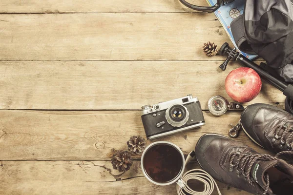 Botas, mochila, brújula y otros equipos de camping sobre un fondo de madera. El concepto de senderismo en las montañas o el bosque, el turismo, el descanso de la tienda, el campamento. Piso tendido, vista superior . — Foto de Stock