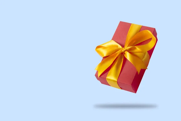 Açık mavi bir arka plan üzerinde uçan hediye kutusu. Tatil konsepti, hediye, satış, düğün ve doğum günü. — Stok fotoğraf