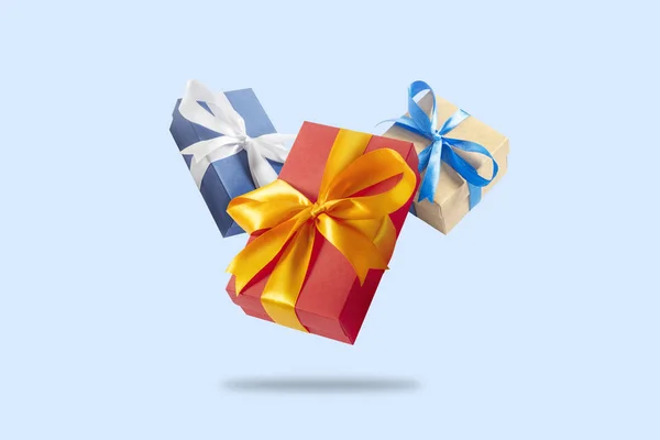 De nombreuses boîtes-cadeaux volantes sur un fond bleu clair. Concept de vacances, cadeau, vente, mariage et anniversaire . — Photo