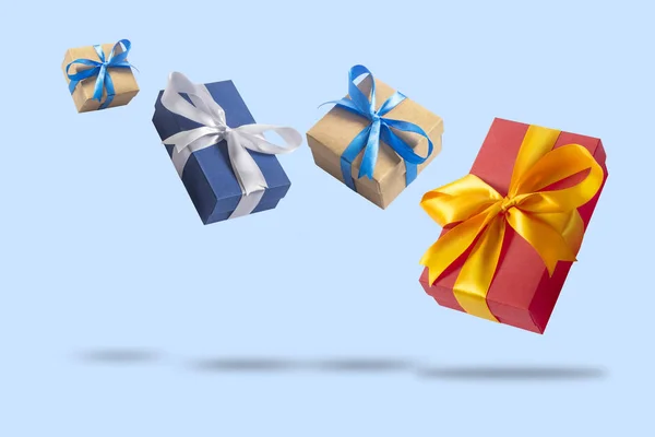 De nombreuses boîtes-cadeaux volantes sur un fond bleu clair. Concept de vacances, cadeau, vente, mariage et anniversaire . — Photo
