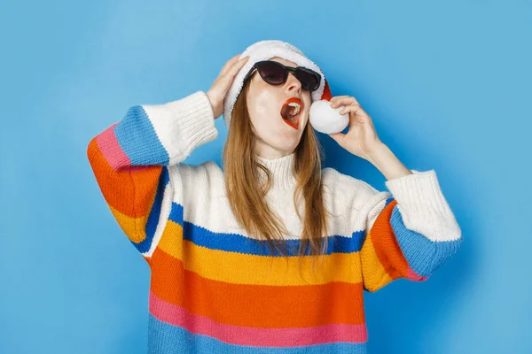 Young girl in Santa Claus hat and glasses on a blue background. The concept of New Year and Christmas. — 스톡 사진