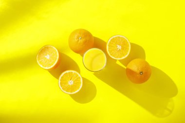 Turuncu lar ve Sarı Arka Plan Üzerine Portakal Suyu Bardağı. Vitamin kavramı, tropik, yaz, susuzluk içeceği. Minimalizm. Doğal ışık. Düz döşeme, üst görünüm.