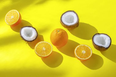 Turuncu lar ve hindistan cevizi sarı bir arka plan üzerinde. Vitamin kavramı, tropik, yaz, kahvaltı. Minimalizm. Doğal ışık. Düz döşeme, üst görünüm.