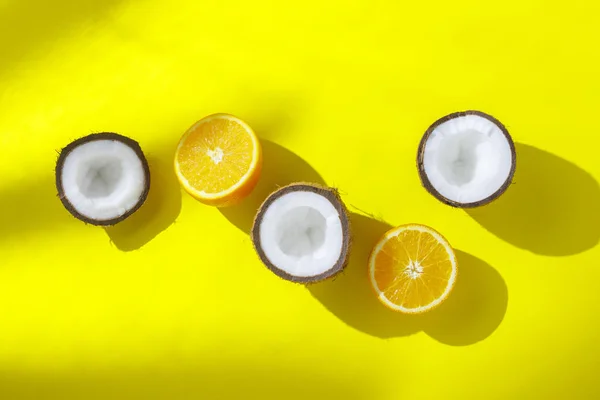 Naranjas y coco sobre un fondo amarillo. Concepto de vitaminas, trópico, verano, desayuno. Minimalismo. Luz natural. Piso tendido, vista superior . — Foto de Stock