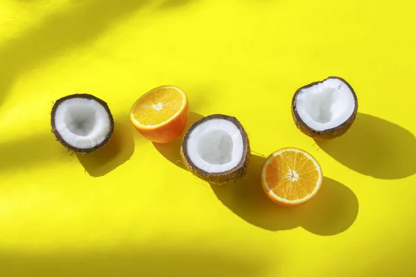 Naranjas y coco sobre un fondo amarillo. Concepto de vitaminas, trópico, verano, desayuno. Minimalismo. Luz natural. Piso tendido, vista superior . — Foto de Stock