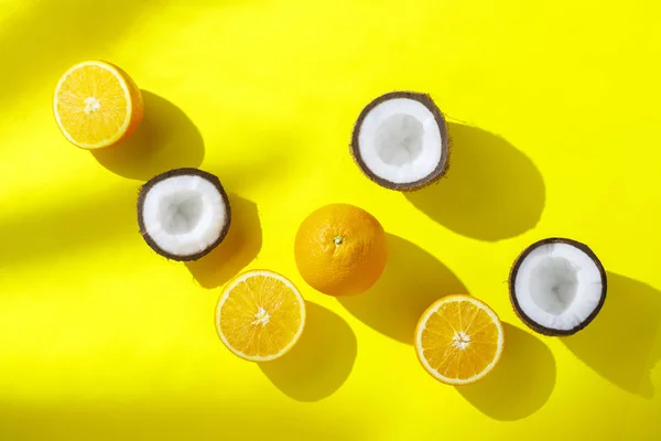 Naranjas y coco sobre un fondo amarillo. Concepto de vitaminas, trópico, verano, desayuno. Minimalismo. Luz natural. Piso tendido, vista superior . — Foto de Stock