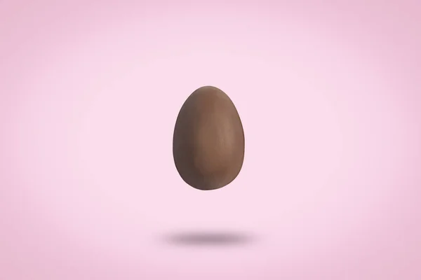 Voando ovo de chocolate em um fundo rosa. Conceito de Páscoa. Levitação. Deitado plano, vista superior . — Fotografia de Stock