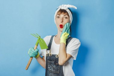 Bahçıvan kıyafetleri içinde şaşırmış bir yüzü olan genç bir kadın...