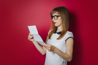 Gülümseyen genç bir kadın koyu pembe bir arka plan üzerine bir mektup okuyor. Kavram bildirimi, iyi haber, üniversiteye kabul onayı