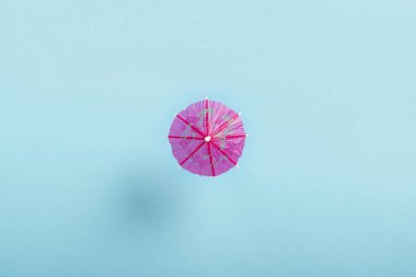 Mavi bir arka planda bir kokteyl için dekoratif şemsiye. Düz La