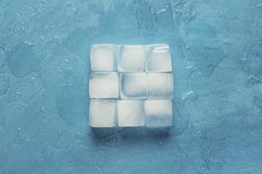 Mavi taş arka planda buz küpleri. Kare şekli. (Paşa)