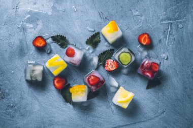 Taş mavi arka planda meyve ve kırık buz ile buz küpleri w