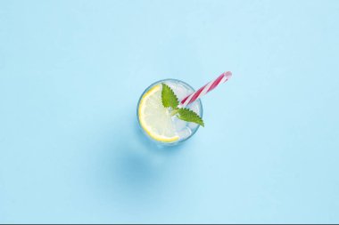 Mavi bir arka üzerinde buz, limon ve nane ile su veya içecek bir bardak