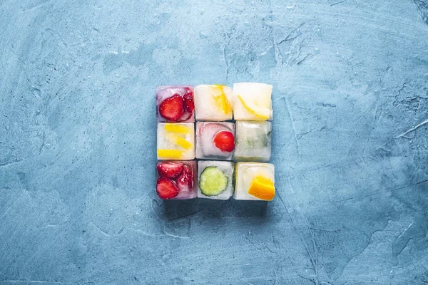 Eiswürfel mit Früchten auf steinblauem Hintergrund. die Form von th — Stockfoto