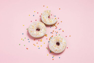 Pembe bir arka plan üzerinde taze lezzetli tatlı çörekler. Fırın konsepti, taze hamur işleri, lezzetli kahvaltı, fast food, kahve dükkanı. Düz döşeme, üst görünüm