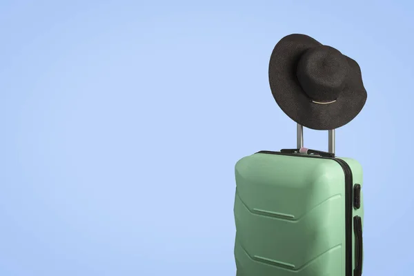 Пластиковый чемодан на колёсах и шляпа с широким краем на хане — стоковое фото