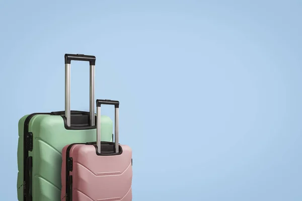 Dwa walizki na kółkach na niebieskim tle. Koncepcja podróży — Zdjęcie stockowe