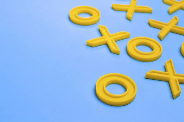 Yellow plastic crosses and zeroches for playing tic-tac-toe on a — Stock Photo, Image