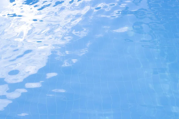 Water vibrations in the swimming pool with sun reflection. blue