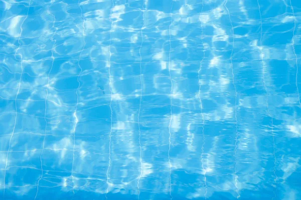 Water vibrations in the swimming pool with sun reflection. blue