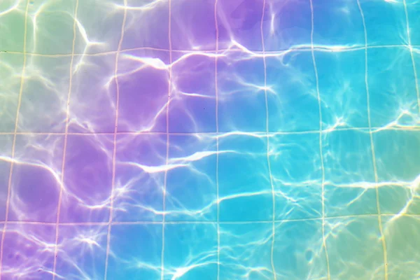 Water vibrations in the swimming pool with sun reflection. blue