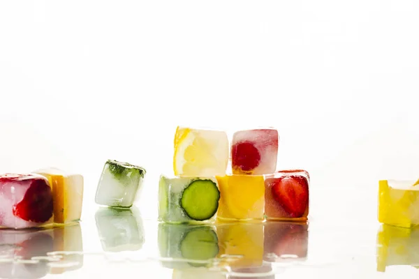 Cubos de gelo com frutas em um fundo branco brilhante. O conceito de verão quente, sobremesa, sorvete. Deitado plano, vista superior — Fotografia de Stock