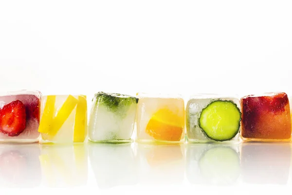 Ice cubes with fruit on a bright white background. The concept of hot summer, dessert, ice cream. Flat lay, top view — Stock Photo, Image