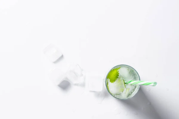 Glas mit einem kühlenden Getränk oder Wasser und Eis auf hellem Hintergrund. Konzept aus Sommercocktails, Durst und Hitze — Stockfoto