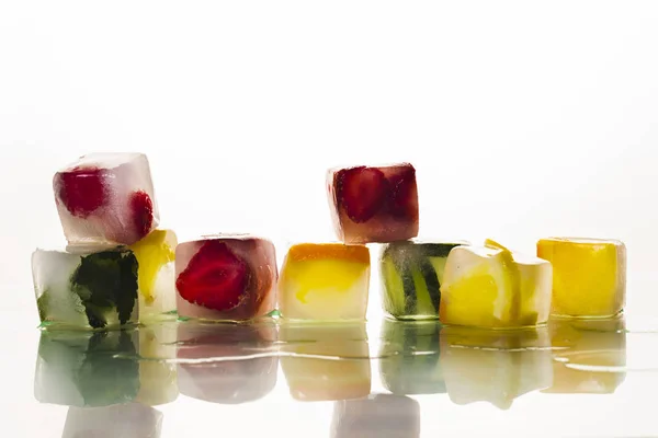 Cubos de gelo com frutas em um fundo branco brilhante. O conceito de verão quente, sobremesa, sorvete. Deitado plano, vista superior — Fotografia de Stock