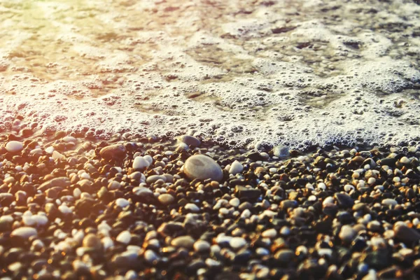 Spiaggia con ciottoli e surf al tramonto o all'alba — Foto Stock