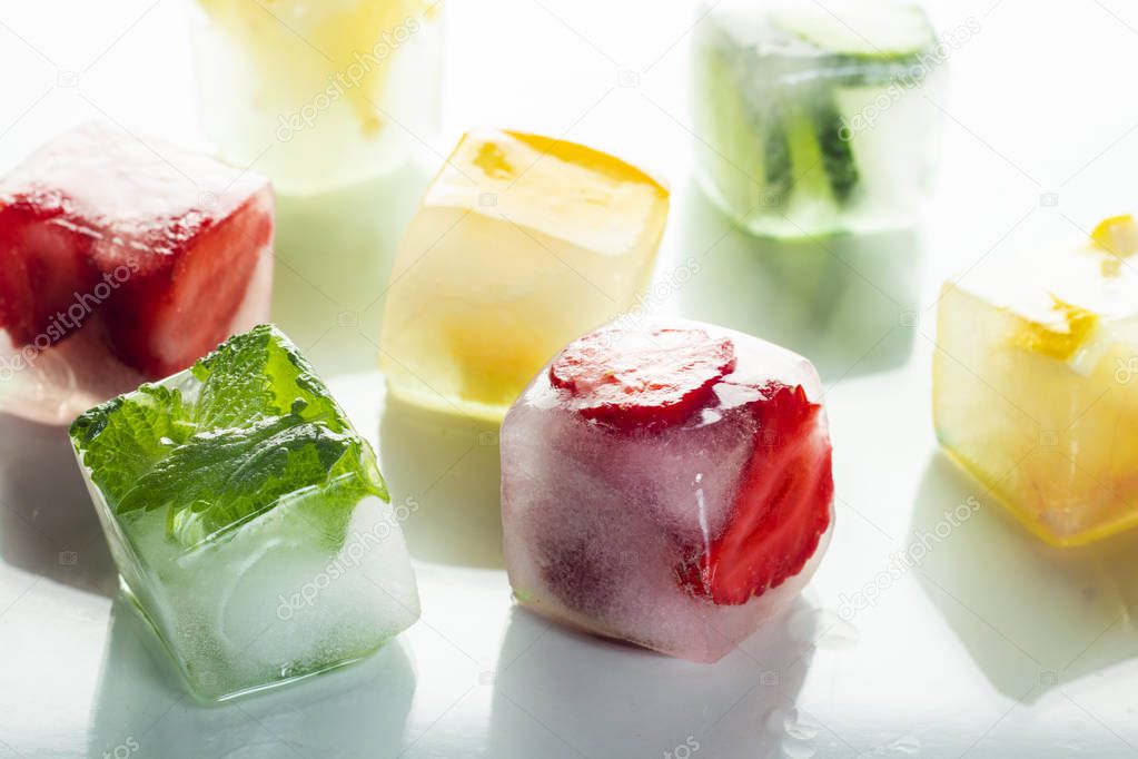 Ice cubes with fruit on a bright white background. The concept of hot summer, dessert, ice cream. Flat lay, top view