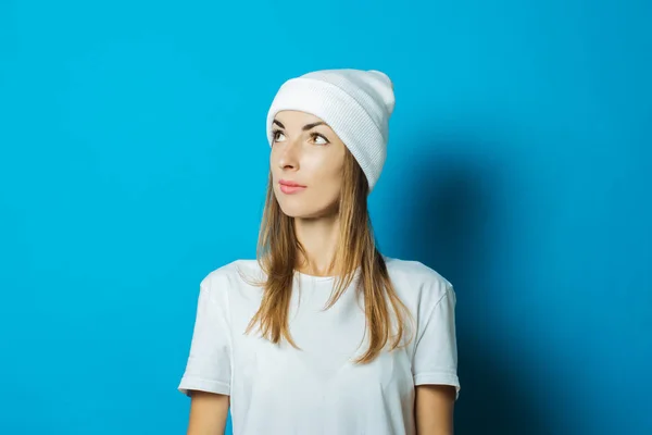 Mujer joven con sombrero blanco y camiseta sobre fondo azul — Foto de Stock